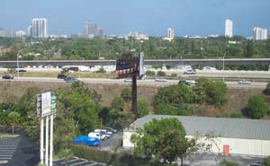 View from hotel window, showing a car park, a highway and, in the distance, the centre of West Palm Beach.